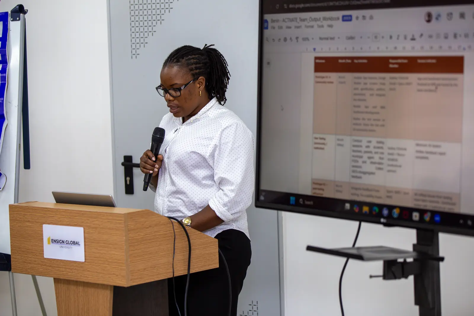 A facilitator presenting programme materials on a large screen